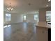 Open floor plan showcasing tile flooring, neutral paint, bright light fixtures, and large windows at 7020 Rolling Leaf Dr, Groveland, FL 34736
