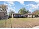 Exterior view of the residence with trees, a yard, and a chain link fence at 7906 Rideout Rd, Riverview, FL at 7906 Arabian Pl, Orlando, FL 32818