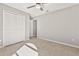Bedroom features tile flooring, closet doors, neutral wall color, and ceiling fan at 823 Kokomo Cir, Port Orange, FL 32127