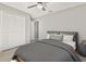 Neutral bedroom featuring tile floors, closet, ceiling fan, and staging furniture at 823 Kokomo Cir, Port Orange, FL 32127