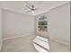 Bright bedroom features a ceiling fan, tile flooring and arched window with natural light at 823 Kokomo Cir, Port Orange, FL 32127