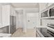 Clean kitchen with white cabinetry, stainless steel appliances and a laundry closet at 823 Kokomo Cir, Port Orange, FL 32127