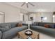 Open living room with modern sofas, a ceiling fan, and an adjacent dining area at 823 Kokomo Cir, Port Orange, FL 32127