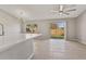 Living room with tile floors, modern light fixture, and sliding glass doors leading to the backyard at 823 Kokomo Cir, Port Orange, FL 32127