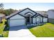 Charming single-Gathering home with a well-manicured lawn, two-car garage, and a modern black and white design at 1060 Jaybee Ave, Davenport, FL 33897