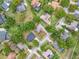 An aerial view showcases a neighborhood with mature trees and well-maintained lawns at 11512 Grand Bay Blvd, Clermont, FL 34711