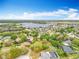 An aerial view showcases a lakeside neighborhood with lush greenery and mature trees at 11512 Grand Bay Blvd, Clermont, FL 34711
