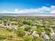 Aerial view featuring a lakeside neighborhood with lush trees and beautiful blue sky at 11512 Grand Bay Blvd, Clermont, FL 34711