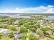 Aerial view featuring a lakeside neighborhood with lush trees and beautiful blue sky at 11512 Grand Bay Blvd, Clermont, FL 34711