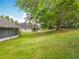 A grassy backyard features mature trees, creating a park-like setting with neighboring homes at 11512 Grand Bay Blvd, Clermont, FL 34711