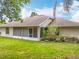 The rear exterior of the home highlighting a screened in porch and view of the backyard at 11512 Grand Bay Blvd, Clermont, FL 34711