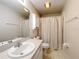 Neutral bathroom featuring a single sink vanity, toilet, and shower with a white shower curtain at 11512 Grand Bay Blvd, Clermont, FL 34711