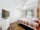 Bright bedroom featuring a ceiling fan and a double bed with a checkered comforter at 11512 Grand Bay Blvd, Clermont, FL 34711