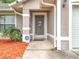 Home's front entry boasts a decorative screen door, ADT security system sign, and manicured landscape at 11512 Grand Bay Blvd, Clermont, FL 34711