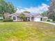 Charming single-story home with a well-maintained lawn, mature landscaping, and attached two-car garage at 11512 Grand Bay Blvd, Clermont, FL 34711