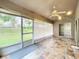 Enclosed lanai with screened windows, tile flooring, and ceiling fan providing outdoor views at 11512 Grand Bay Blvd, Clermont, FL 34711