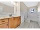 Bathroom featuring granite countertop, wood cabinetry, and shower-tub combo at 1203 Judy Ave, Tavares, FL 32778