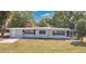 Well-maintained single-story home with blue shutters and mature landscaping at 1203 Judy Ave, Tavares, FL 32778