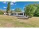 Charming single-story home features a manicured lawn and quaint blue shutters at 1203 Judy Ave, Tavares, FL 32778