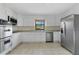 Updated kitchen with stainless steel appliances, granite countertops, and bright white cabinets at 1203 Judy Ave, Tavares, FL 32778