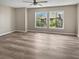 Spacious bedroom with new hardwood floors and natural light from windows overlooking exterior greenery at 126 Maitland Ave # 126, Altamonte Springs, FL 32701