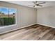Bright bedroom featuring wood-look floors, a ceiling fan, and a large window at 126 Maitland Ave # 126, Altamonte Springs, FL 32701