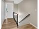 Upstairs hallway with wood-look flooring, railing, and a view into the bedroom at 126 Maitland Ave # 126, Altamonte Springs, FL 32701
