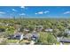 Aerial view showcases a neighborhood with lush tree cover and a skyline in the distance at 1312 Vassar St, Orlando, FL 32804