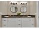 Modern bathroom features dual sinks, grey countertop, white cabinetry, and stylish octagonal mirrors at 1312 Vassar St, Orlando, FL 32804