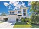 Beautiful two-story modern home with a two-car garage, gorgeous landscaping, blue sky, and a walkway to the front door at 1312 Vassar St, Orlando, FL 32804