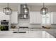 Bright kitchen with white cabinets, modern lighting, stainless steel appliances, and a stylish backsplash at 1312 Vassar St, Orlando, FL 32804