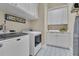 Well-organized laundry room boasts modern appliances, ample storage cabinets and counterspace with stylish floor tiles at 1312 Vassar St, Orlando, FL 32804
