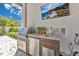 Outdoor kitchen with stainless steel grill, mini refrigerator, granite countertop, and television at 1312 Vassar St, Orlando, FL 32804