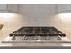 Close-up of a Samsung stovetop with a stainless steel finish and detailed tile backsplash at 1312 Vassar St, Orlando, FL 32804