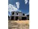Unfinished two-story home showing Tyvek HomeWrap and black framed windows under a bright blue sky at 1402 Stetson St, Orlando, FL 32804