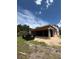 Unfinished home showing Tyvek HomeWrap and black framed windows on a partially grassy lot with blue skies above at 1402 Stetson St, Orlando, FL 32804
