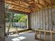 A garage being constructed with concrete block walls and exposed rafters, revealing a sunlit exterior view at 1402 Stetson St, Orlando, FL 32804
