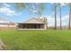 Expansive backyard featuring a lush lawn, mature trees, and a screened lanai, creating a private outdoor oasis at 14026 Eckard Ct, Orlando, FL 32826