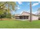 Side view of the home and spacious backyard with mature trees and a wooden fence offering a private outdoor retreat at 14026 Eckard Ct, Orlando, FL 32826