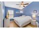 Stylish blue bedroom with light hardwood floors, ceiling fan, and TV at 14026 Eckard Ct, Orlando, FL 32826