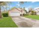 Single-story home with a manicured lawn, a two-car garage and mature landscaping at 14026 Eckard Ct, Orlando, FL 32826