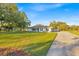 Charming single-story home featuring a spacious front yard, long driveway and well manicured green spaces at 141 Greenfield Rd, Winter Haven, FL 33884