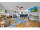 Cozy living room with a large TV, a comfortable recliner, hardwood floors, and modern lighting at 141 Greenfield Rd, Winter Haven, FL 33884