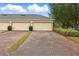 Three-car garage with brick paver driveway surrounded by well-maintained landscaping at 14467 Prunningwood Pl, Winter Garden, FL 34787
