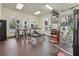 Bright gym features modern equipment, treadmills, weights, and mounted TV's, with windows and views to the community pool at 14467 Prunningwood Pl, Winter Garden, FL 34787