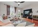 Well-lit living room with a white couch, hardwood floors, and stylish media center at 14467 Prunningwood Pl, Winter Garden, FL 34787