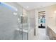 Bright bathroom featuring marble tile, glass-enclosed shower and tub, and open doorway to bedroom at 15343 Rising View Dr, Montverde, FL 34756