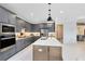 Modern kitchen with gray cabinets, quartz countertops, stainless steel appliances, and large center island at 15343 Rising View Dr, Montverde, FL 34756
