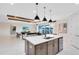 Bright kitchen with island, sink, dishwasher, and view into an open-concept living room with wooden ceiling beams at 15343 Rising View Dr, Montverde, FL 34756