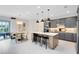 Contemporary kitchen featuring a central island with bar stools and modern grey cabinets and appliances at 15343 Rising View Dr, Montverde, FL 34756
